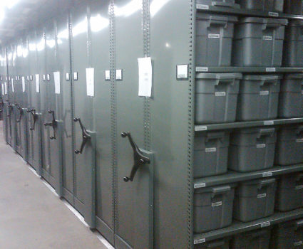 Police department evidence storage in bins on mobile shelving system 3, green end panel with chain guard cover